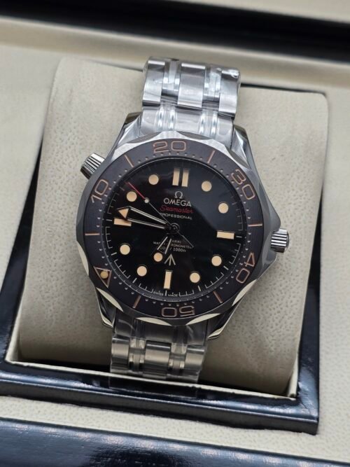 Omega — esfera negra con detalles beige, bisel marrón y brazalete de acero