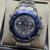 Omega — cronógrafo con esfera gris ondulada, bisel azul y brazalete de acero