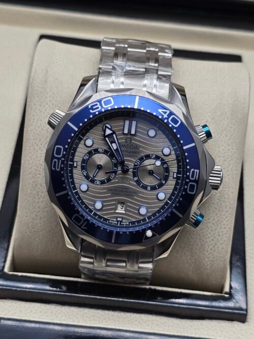 Omega — cronógrafo con esfera gris ondulada, bisel azul y brazalete de acero