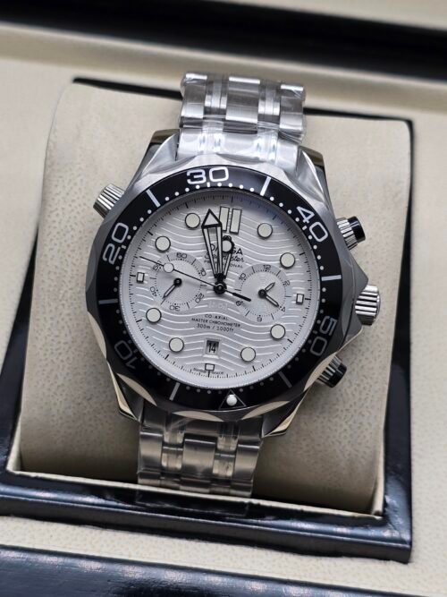 Omega — cronógrafo con esfera blanca ondulada, bisel negro y brazalete de acero