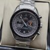 Omega — cronógrafo con esfera gris y detalles naranjas, brazalete de acero
