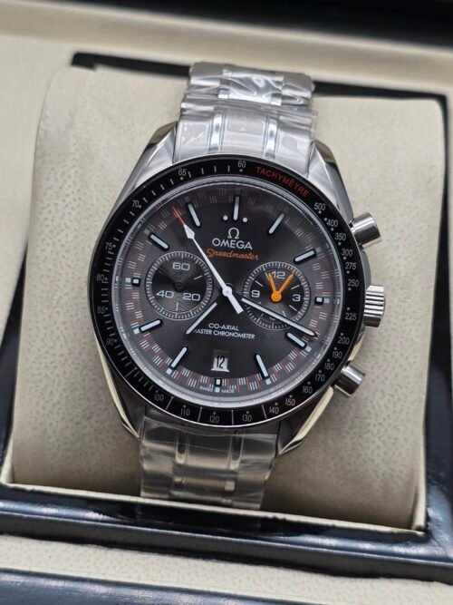 Omega — cronógrafo con esfera gris y detalles naranjas, brazalete de acero