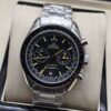 Omega — cronógrafo con esfera negra y detalles amarillos, brazalete de acero