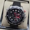 Omega — cronógrafo con esfera negra ondulada, detalles rojos y correa de caucho negra