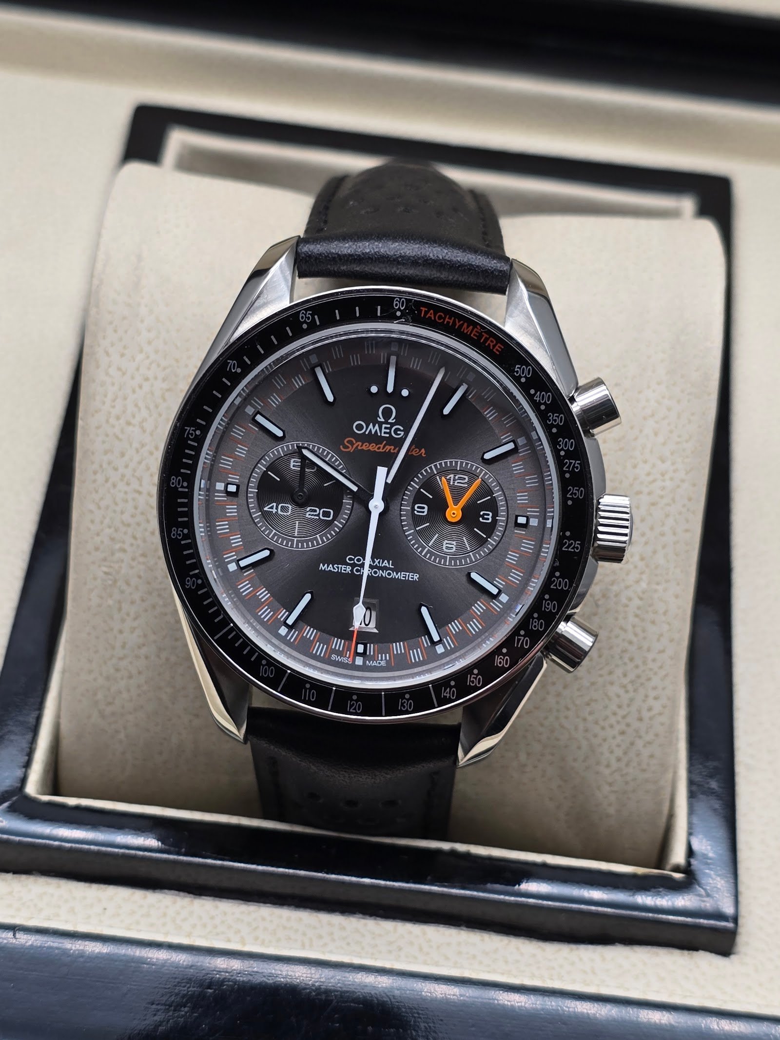 Omega — cronógrafo con esfera gris y detalles naranjas, correa de cuero negra