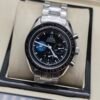 Omega — cronógrafo con esfera negra y detalle azul, brazalete de acero
