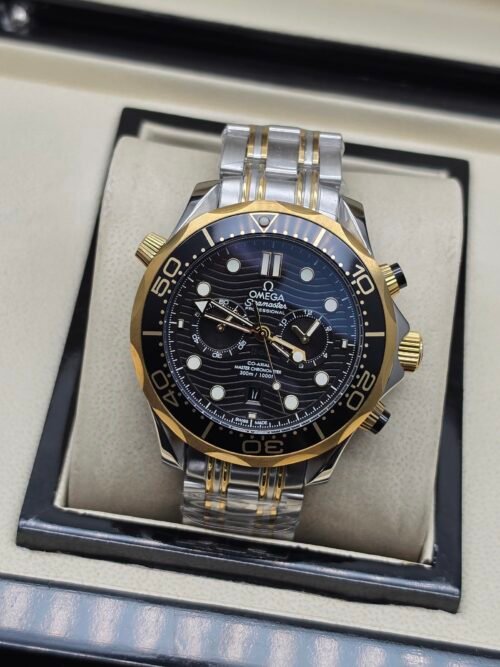 Omega — cronógrafo con esfera negra ondulada, bisel dorado y brazalete bicolor