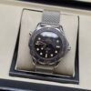 Omega — esfera negra con detalles beige, bisel marrón y brazalete de malla de acero