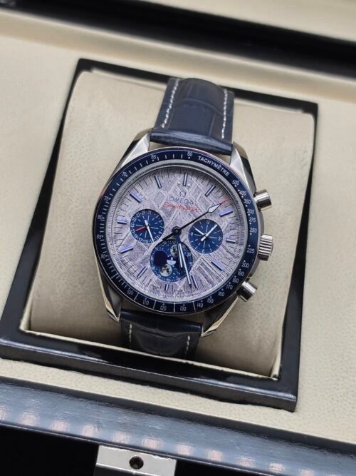 Omega — cronógrafo con esfera plateada texturizada y subesferas azules, correa de cuero azul