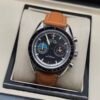 Omega — cronógrafo con esfera negra y agujas de colores, correa de cuero marrón claro