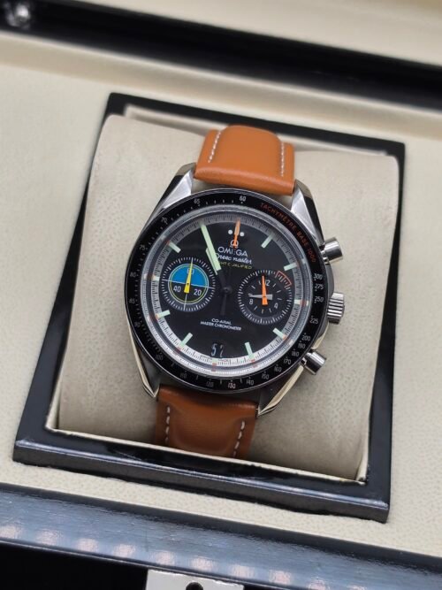 Omega — cronógrafo con esfera negra y agujas de colores, correa de cuero marrón claro
