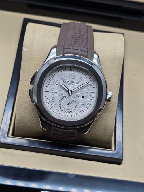 Patek Philippe — esfera blanca con reserva de marcha y correa de caucho marrón