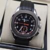 Patek Philippe — cronógrafo con esfera negra y detalles naranjas, correa de caucho negra