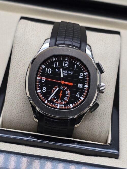 Patek Philippe — cronógrafo con esfera negra y detalles naranjas, correa de caucho negra