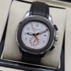 Patek Philippe — cronógrafo con esfera blanca y detalles naranjas, correa de caucho negra
