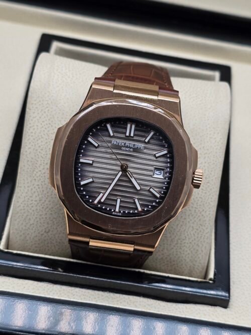 Patek Philippe — caja oro rosa, esfera gris con relieve horizontal y correa de cuero marrón
