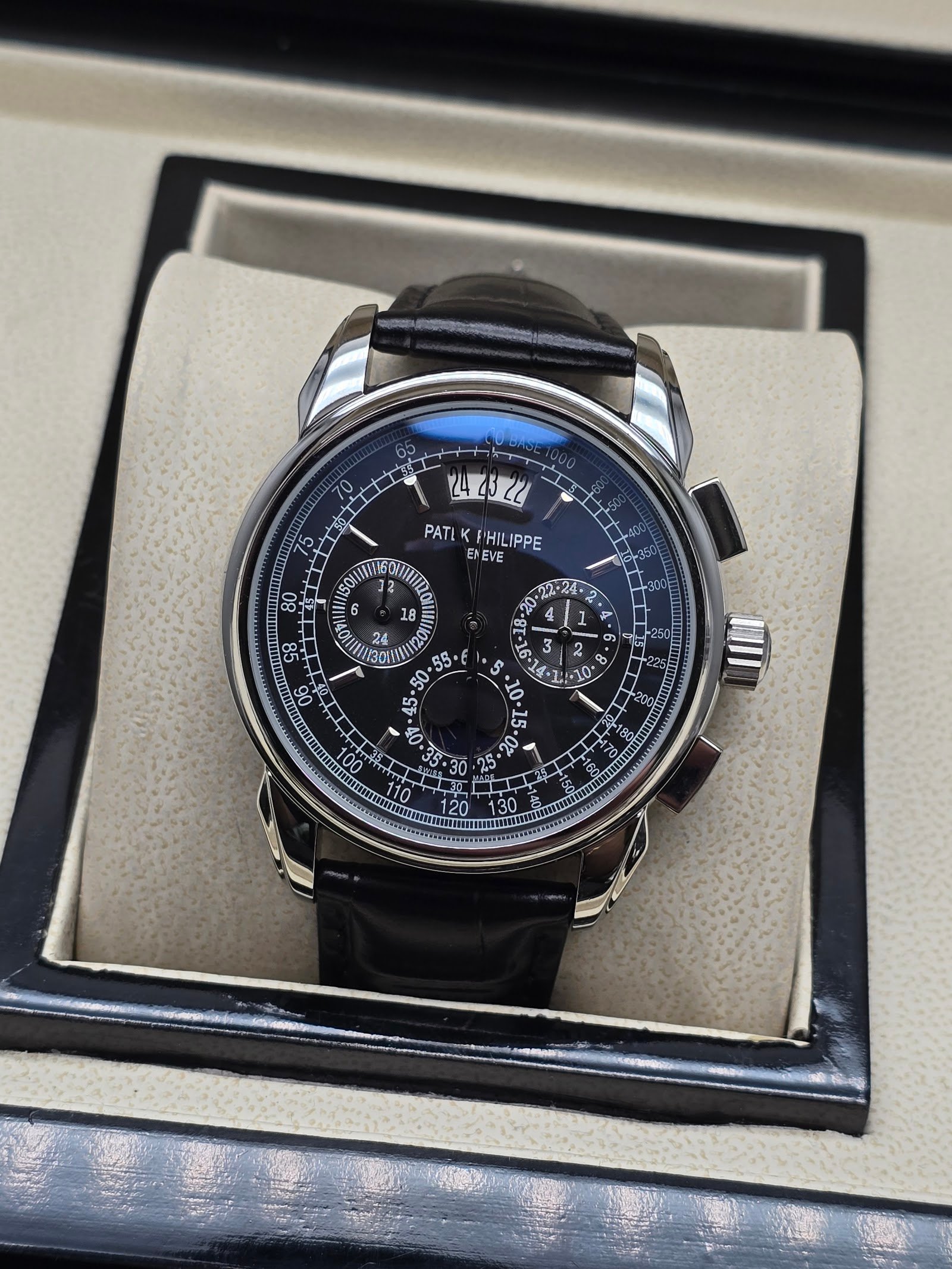 Patek Philippe — cronógrafo con esfera negra y fases lunares, caja de acero y correa de cuero negra