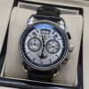Patek Philippe — cronógrafo con esfera blanca y fases lunares, caja de acero y correa de cuero negra