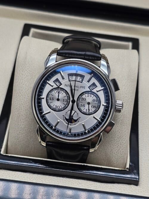 Patek Philippe — cronógrafo con esfera blanca y fases lunares, caja de acero y correa de cuero negra