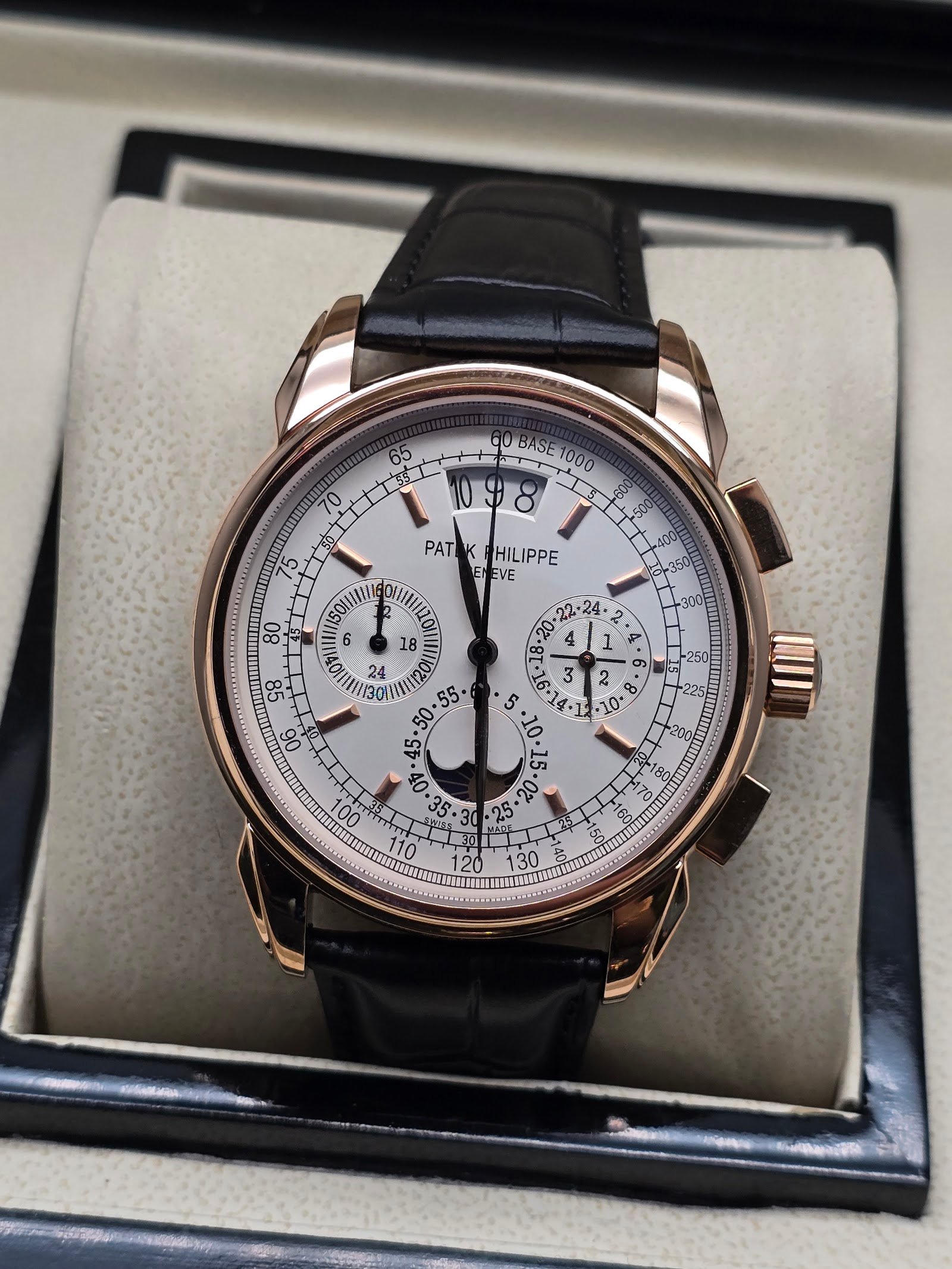 Patek Philippe — cronógrafo con esfera blanca y fases lunares, caja oro rosa y correa de cuero negra
