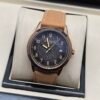 Patek Philippe — caja oro rosa, esfera negra texturizada con números dorados y correa de cuero camel
