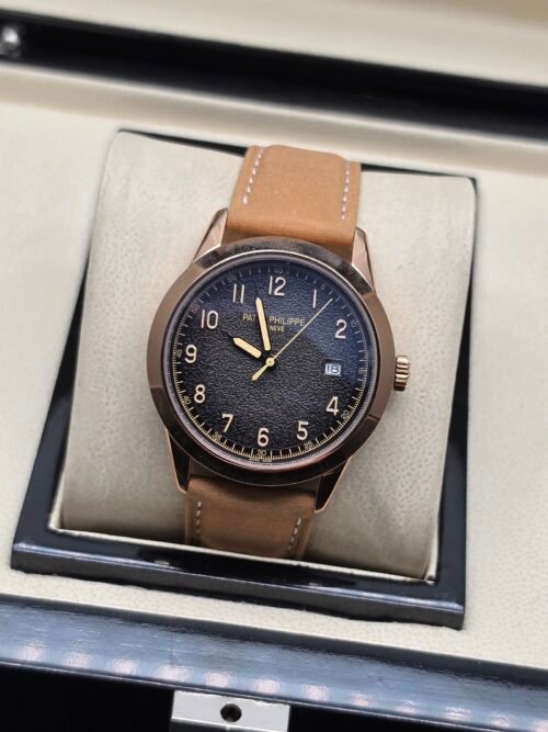 Patek Philippe — caja oro rosa, esfera negra texturizada con números dorados y correa de cuero camel