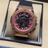 Hublot — cronógrafo con esfera negra y detalles rojos, caja oro rosa y correa negra