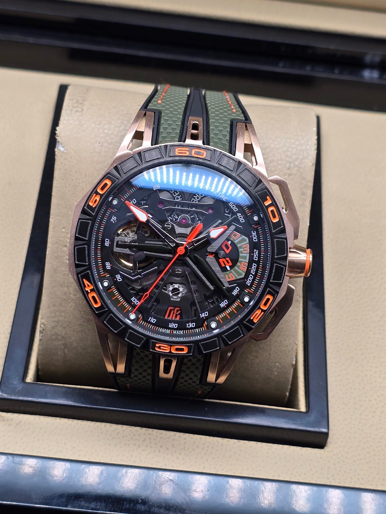 Roger Dubuis — esfera esqueleto con detalles naranjas, caja oro rosa y correa verde militar