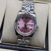 Rolex — esfera rosada con números romanos, bisel estriado y brazalete jubilee de acero