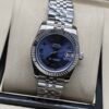 Rolex — esfera azul con números romanos, bisel estriado y brazalete jubilee de acero