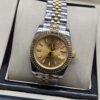 Rolex — esfera champaña, bisel dorado estriado y brazalete jubilee bicolor