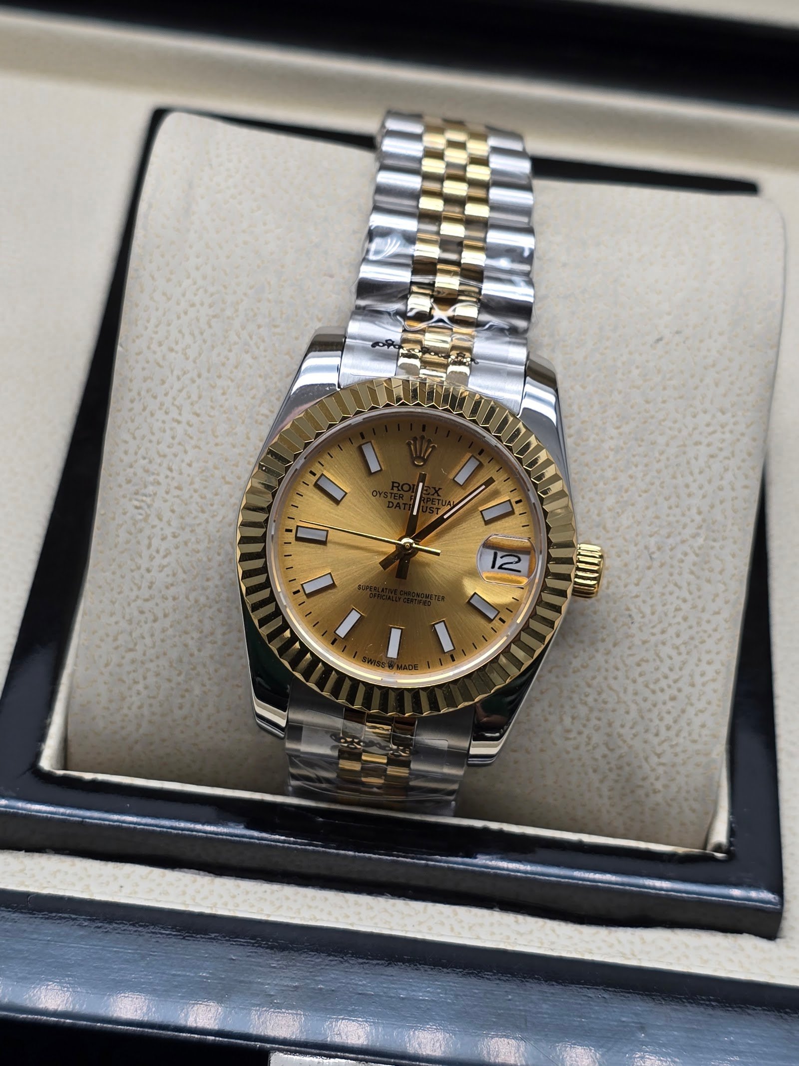 Rolex — esfera champaña, bisel dorado estriado y brazalete jubilee bicolor