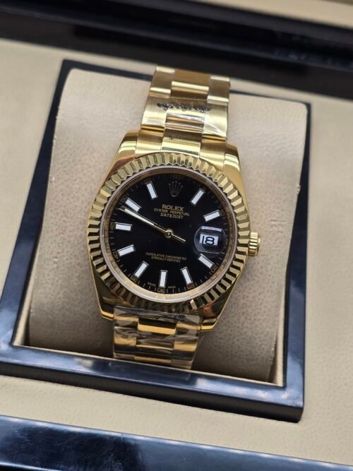 Rolex — esfera negra, bisel dorado estriado y brazalete dorado