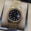 Rolex — esfera negra, bisel dorado estriado y brazalete jubilee dorado