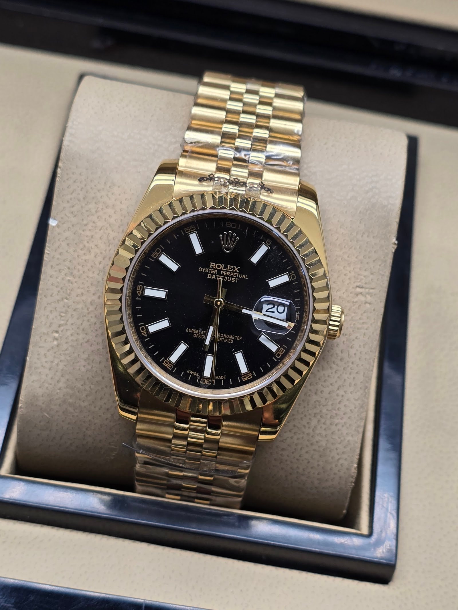 Rolex — esfera negra, bisel dorado estriado y brazalete jubilee dorado