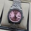 Rolex — esfera rosada con números romanos, bisel estriado y brazalete jubilee de acero