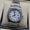 Rolex — esfera blanca con números romanos, bisel estriado y brazalete jubilee de acero