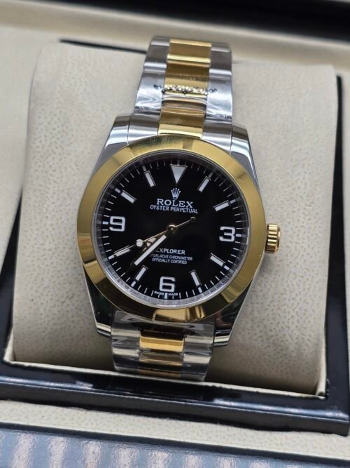 Rolex — esfera negra con números 3-6-9, bisel dorado y brazalete bicolor