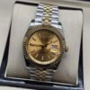 Rolex — esfera champaña, bisel dorado estriado y brazalete jubilee bicolor