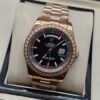 Rolex — esfera negra con día y fecha, bisel de brillantes y brazalete oro rosa