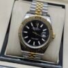 Rolex — esfera negra, bisel dorado estriado y brazalete jubilee bicolor