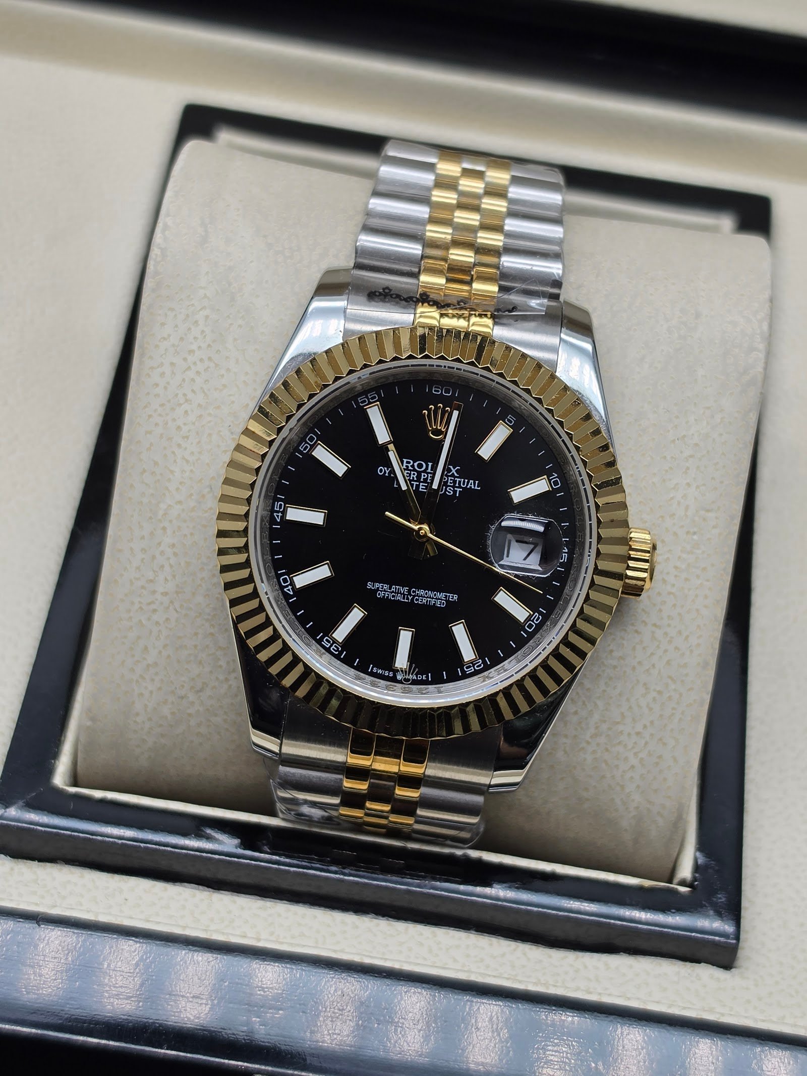 Rolex — esfera negra, bisel dorado estriado y brazalete jubilee bicolor