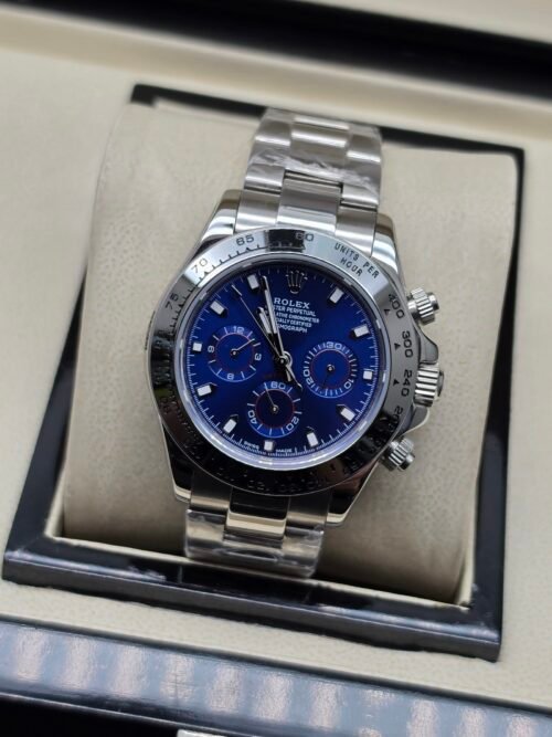 Rolex — cronógrafo con esfera azul, bisel negro y brazalete de acero