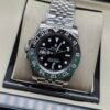 Rolex — esfera negra con doble huso horario, bisel verde y negro y brazalete jubilee de acero