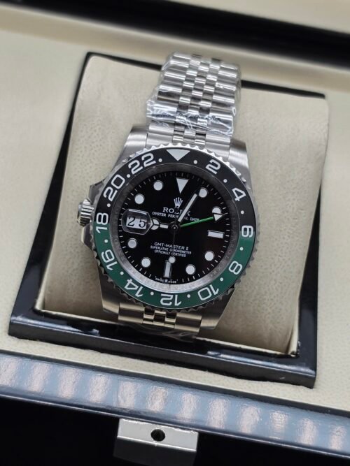 Rolex — esfera negra con doble huso horario, bisel verde y negro y brazalete jubilee de acero