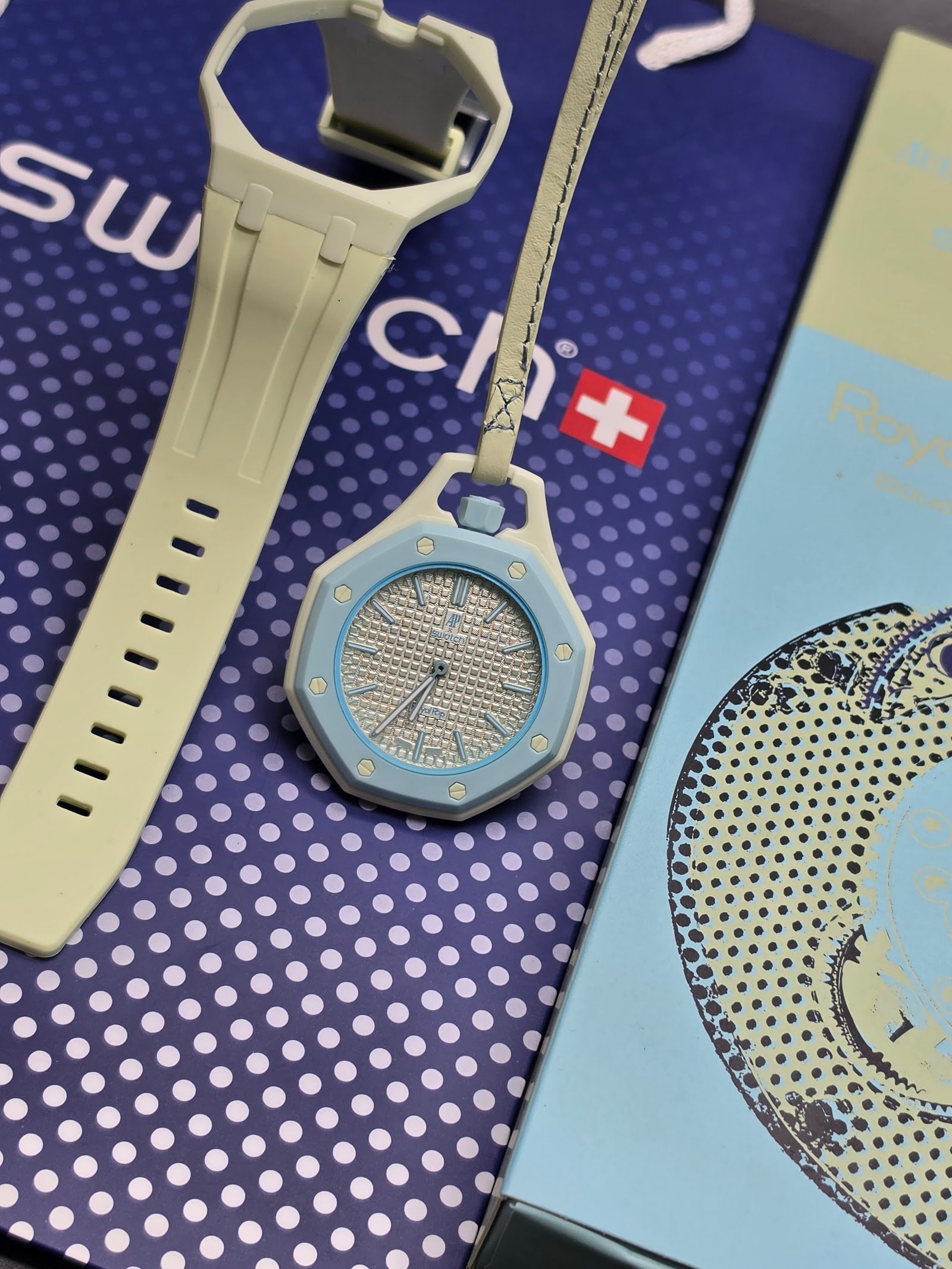 Swatch — reloj de bolsillo octagonal celeste con esfera clara y correa beige
