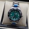 TAG Heuer — esfera verde ondulada, bisel negro y brazalete de acero