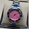 TAG Heuer — esfera rosada ondulada, bisel negro y brazalete de acero