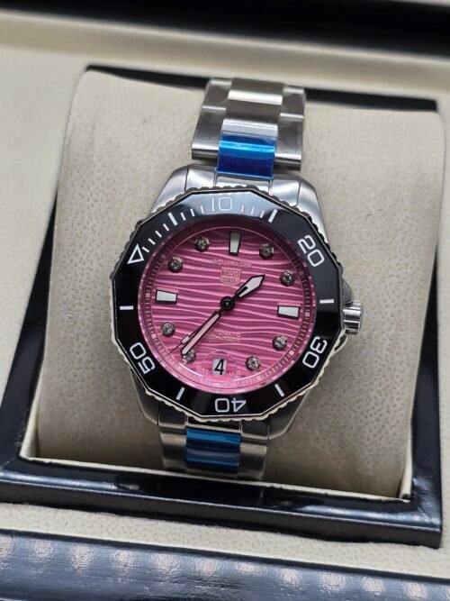 TAG Heuer — esfera rosada ondulada, bisel negro y brazalete de acero