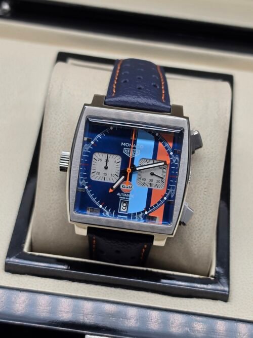 TAG Heuer — cronógrafo cuadrado con esfera azul y franjas celeste y naranja, correa de cuero azul